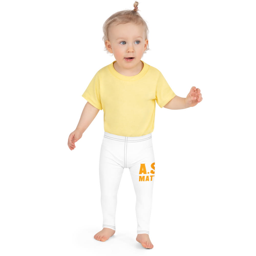 Smiling toddler in a yellow tee and white A.S.K. leggings