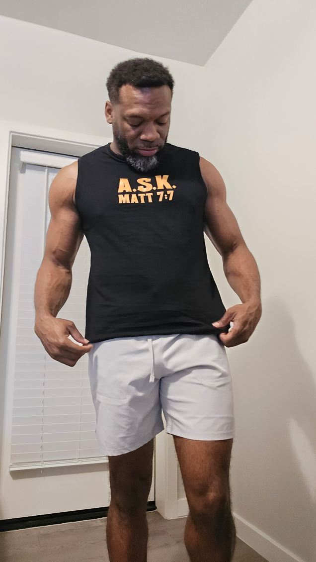 Man in a black A.S.K. sleeveless shirt with Matt 7:7
